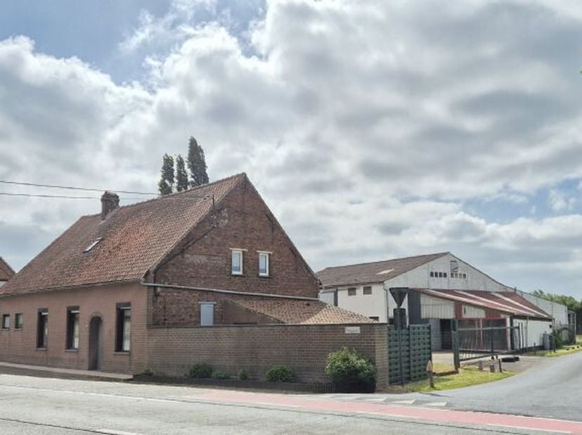 Vlot bereikbare alleenstaande woning met magazijn/werkplaats te Langemark omvattende o.a.:  Living met salon en eetplaats.  Ingerichte aparte keuken.